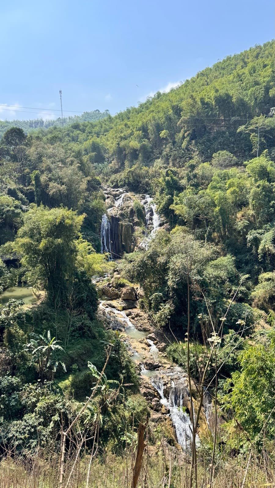 A waterfall tumbling down a forested hillside near Mai Châu