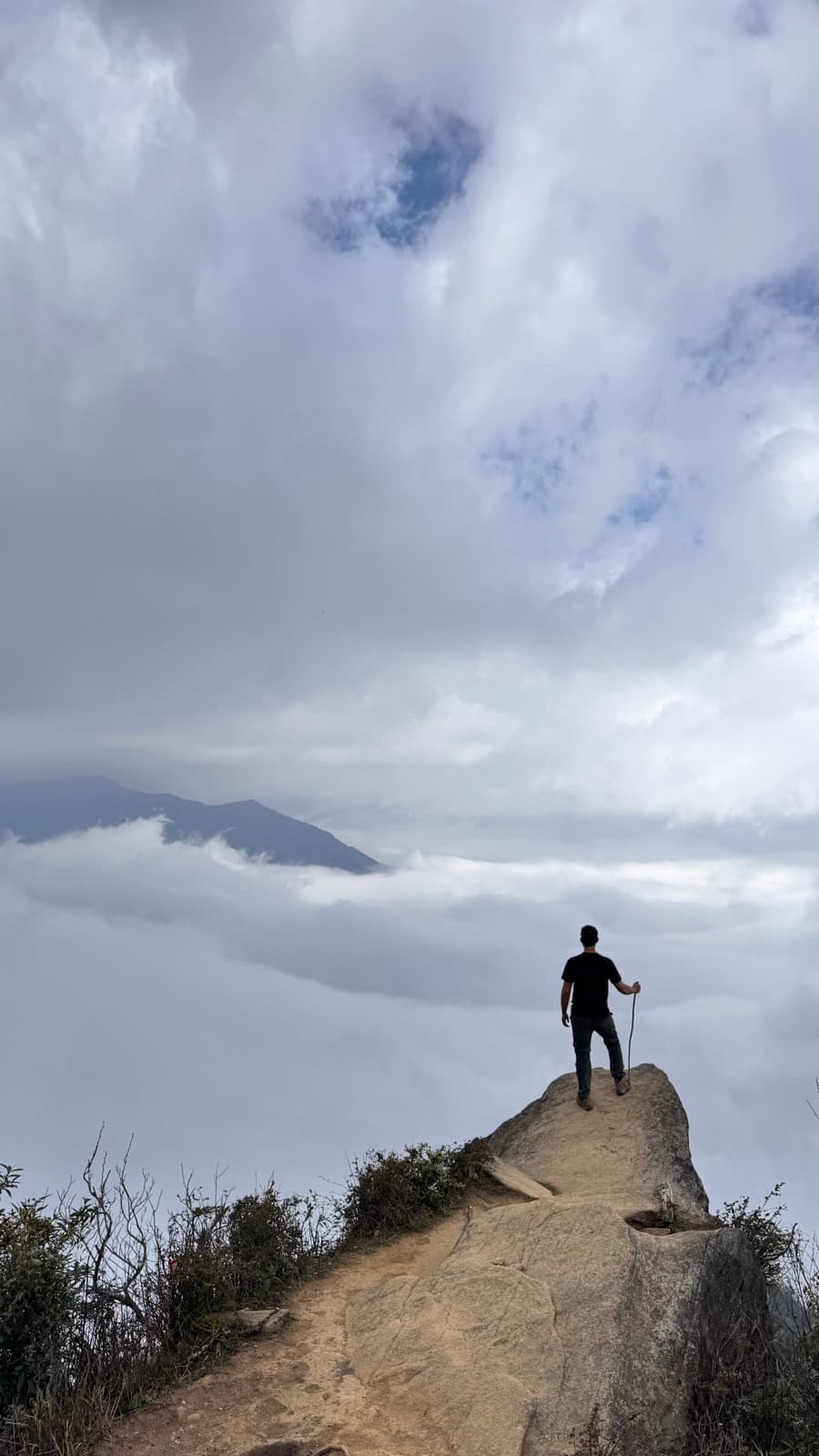 Standing on a rocky spine above a sea of clouds in Tà Xùa