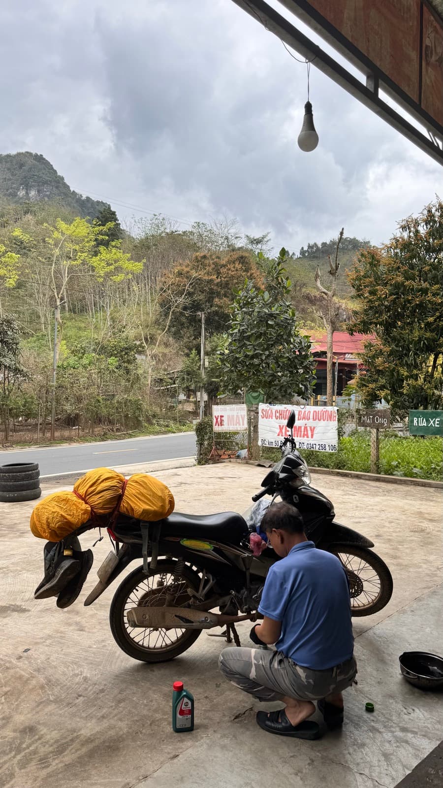 A roadside mechanic servicing a loaded touring bike