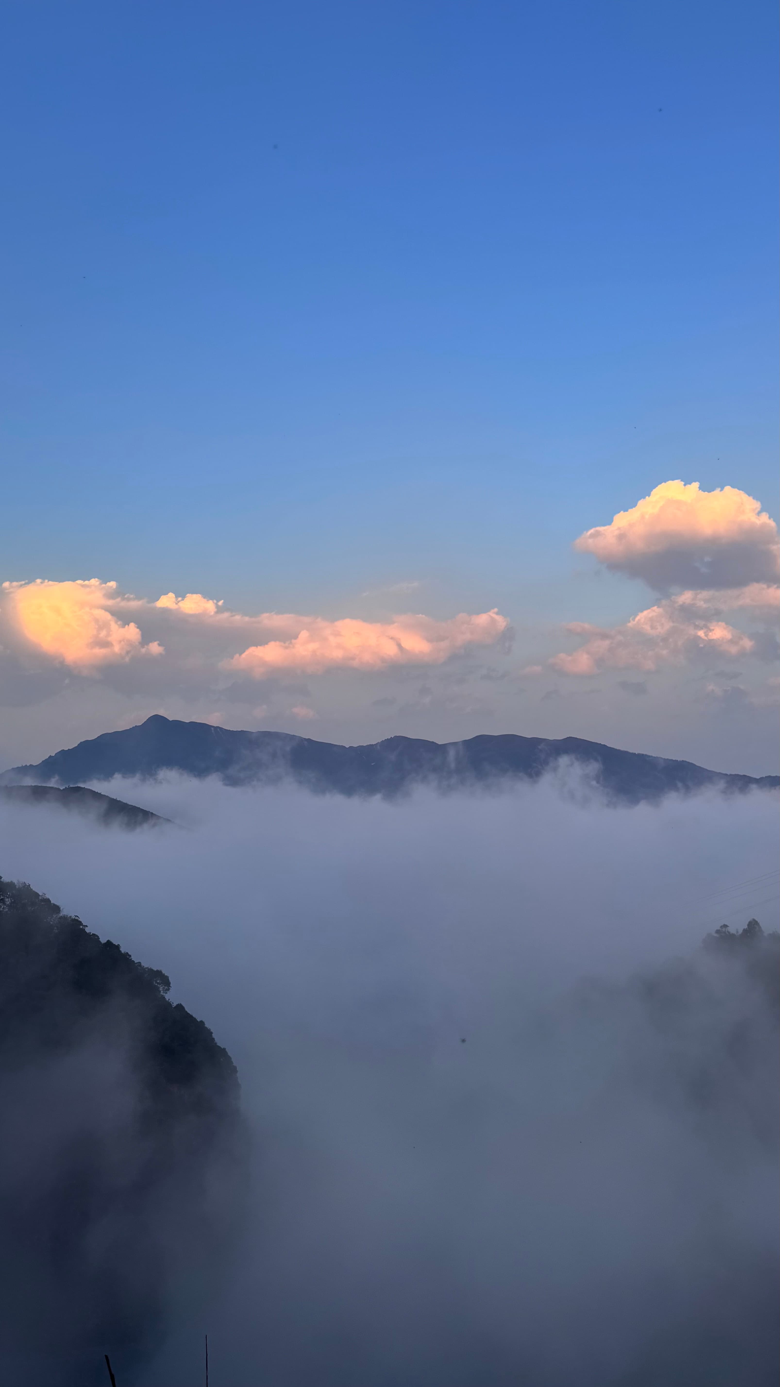 Mountain peaks rising above a sea of clouds at sunrise in Sa Pa