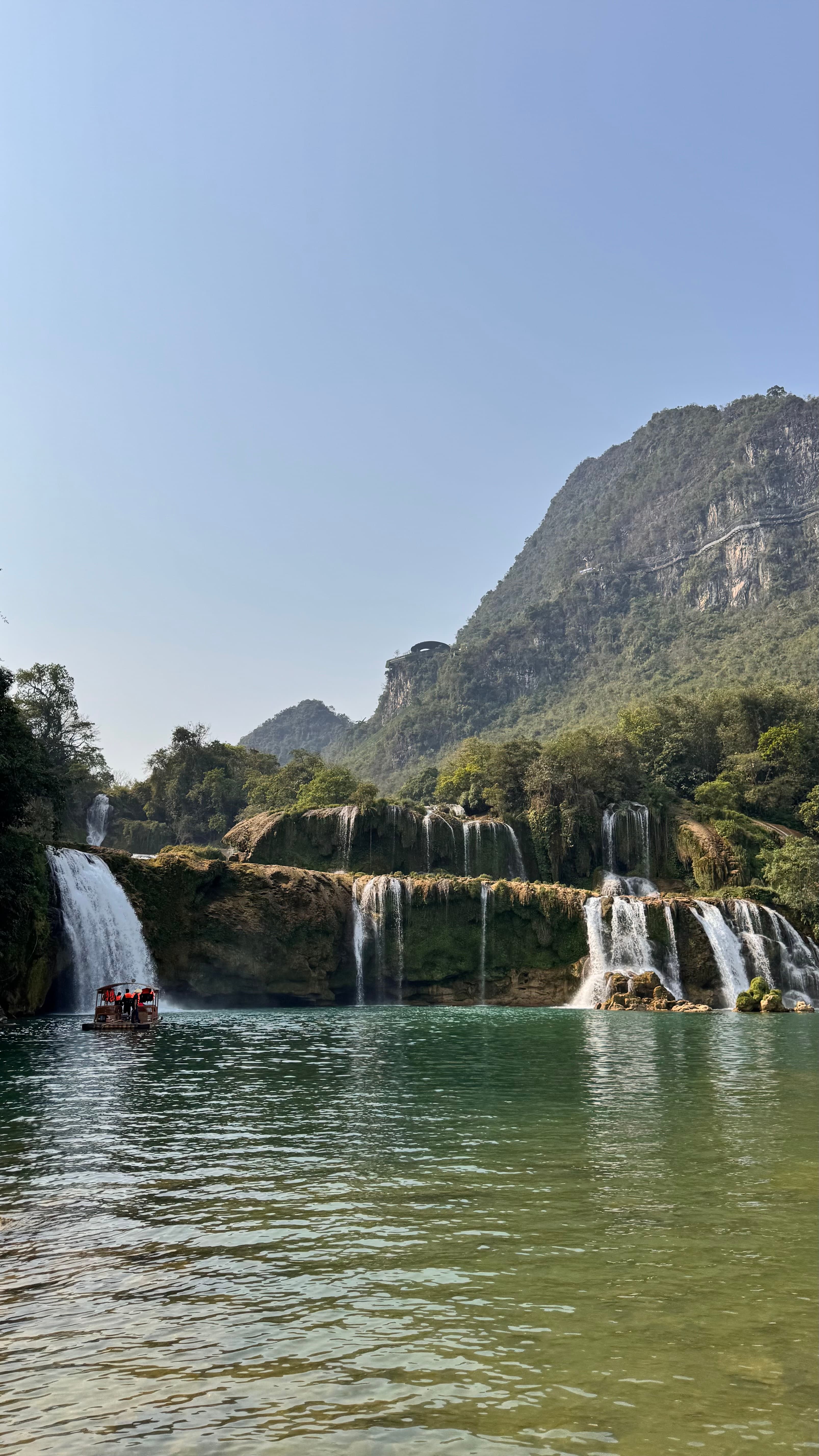Bản Giốc Waterfall cascading into a green river in Cao Bằng