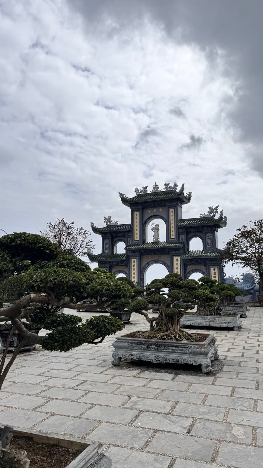 Ornate pagoda gate above a courtyard of bonsai trees in Đà Nẵng